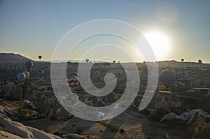 Hot air balloons flying over the valley and rock formations with fairy chimneys near Goreme, Cappadocia, Turkey