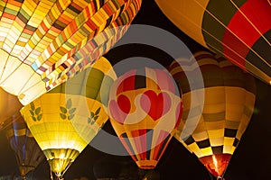 Hot air balloons glow at night float in festival