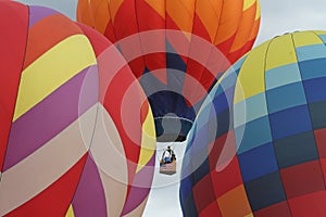 Hot air balloons inflate during a mass ascension