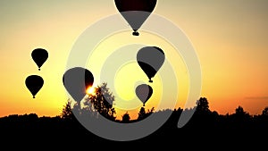 Hot air balloons landing over amazing sunset sun light. Dramatic color grading