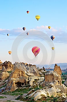 Hot air balloons over mountain landscape in Cappadocia