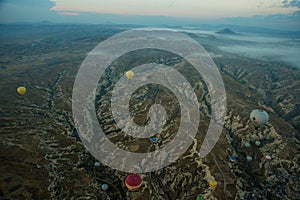 Hot air balloons over mountain landscape in Cappadocia, Goreme National Park, Turkey. Aerial view from air balloon