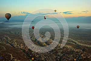 Hot air balloons over mountain landscape in Cappadocia, Goreme National Park, Turkey. Aerial view from air balloon