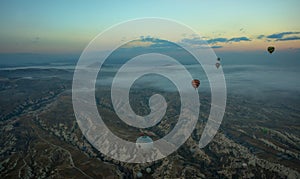 Hot air balloons over mountain landscape in Cappadocia, Goreme National Park, Turkey. Aerial view from air balloon