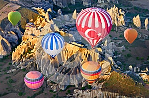 Hot air balloons over mountain landscape in Cappadocia, Turkey