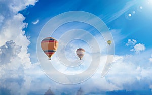 Hot air balloons rising above serene sea, light from heaven, white clouds reflected in water