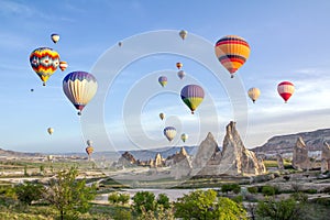 Hot air balloons in the sky over the cave town, Valley of Daggers, Cappadocia, Turkey