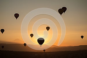 Hot air balloons in the sky during sunrise. Flying over the valley at Cappadocia, Anatolia, Turkey. Volcanic mountains in Goreme n