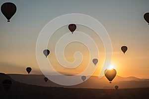 Hot air balloons in the sky during sunrise. Flying over the valley at Cappadocia, Anatolia, Turkey. Volcanic mountains in Goreme n
