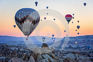 Hot air balloons between the texture of rocks in cappadoccia at sunrise