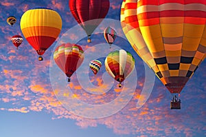 Hot air balloos above golden clouds at sunset, colorful hot air balloons over orange sky.