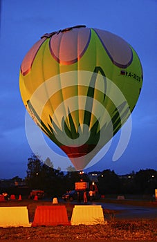 Hot air baloon starting to fly in the evening sky