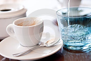 Hot aromatic espresso cup and cold water in glass