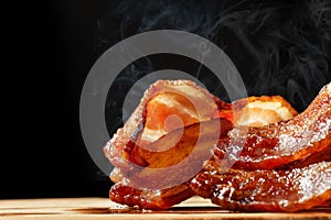 Hot Bacon With Steam Isolated on Black photo