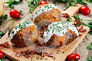 Hot Baked Potato with cheese, bacon, chives and sour cream. photo