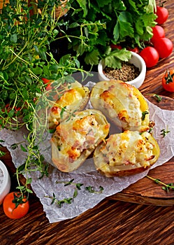 Hot Baked stuffed Potato with cheese, bacon, parsley on wooden table.