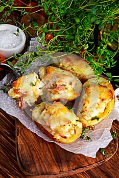 Hot Baked stuffed Potato with cheese, bacon, parsley on wooden table.