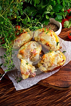Hot Baked stuffed Potato with cheese, bacon, parsley on wooden table.