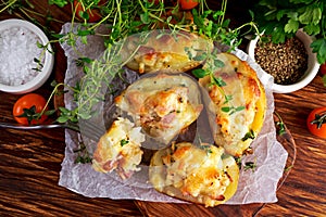 Hot Baked stuffed Potato with cheese, bacon, parsley on wooden table.