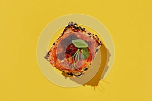 Hot baked suchi roll with salmon on yellow background