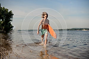 Hot beach lifeguard running along the river bank with life-saving equipment