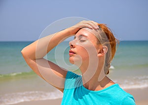 Hot beach and young woman. Woman on hot beach with sunstroke. Health problem on holiday.