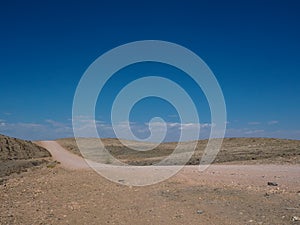 Hot beautiful day on adventure road trip through desert rock mountain landscape route to emptiness with blue sky background