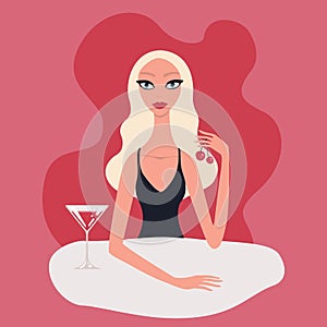 Hot beautiful young blond woman wearing black evening dress drinking cocktail with cherries