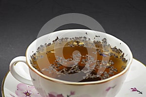 Hot beverage. Cup of tea with tea leaves in it. Ceramics. Close-up view