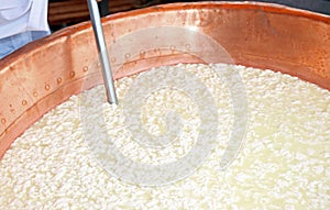 hot big copper cauldron with the curdled milk for the production