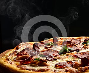 Hot big pepperoni pizza tasty pizza composition with melting cheese bacon tomatoes ham paprika steam smoke