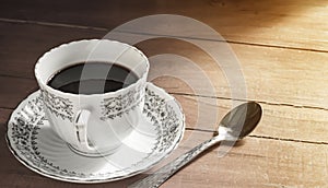 hot black coffee in the classic white luxury coffee cup set on a beautiful vintage dark old wooden table