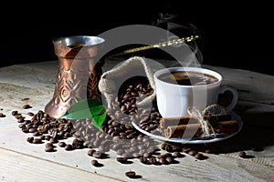 Hot Black Coffee in Coffee Pot and White Coffee Cup with Coffee Beans on Black