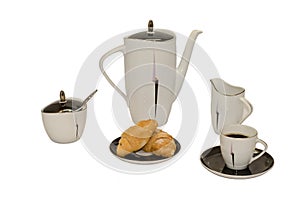 Hot black coffee with croissants. Near the coffee pot, sugar bowl and a cup of milk.