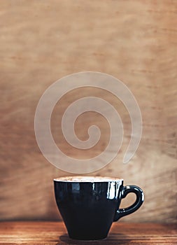 Hot black coffee cup cappuccino on wood table with wood wall.leave copy space for adding text