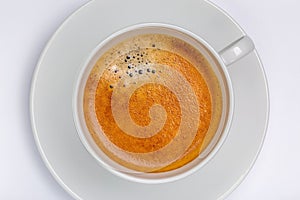 Hot black coffee with foam bubbles in white cup with white background, morning coffee concept.