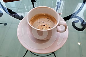 Hot black coffee placed in a glass table.