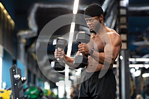 Hot black guy exercising with two dumbbells
