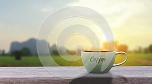 Hot black hot coffee drink with smoke on a wood table. The blurred background landscape panorama of nature with mountains and