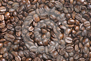 Hot black roasted arabica coffee beans with smoke effect