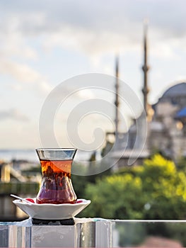 Hot black Turkish tea. Cups of Turkish tea with a saucer against the backdrop of the Hagia Sophia at dawn. Vertical