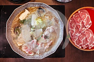 Hot and Boiling Shabu broth with cabbage, eryngii, enotitake, tofu and Kurobuta pork inside hot pot