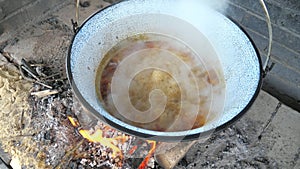 Hot bubbling orange ed sauce of boiling goulash soup with shoped beef. Bubblewith meat and herbs in a deep pot.