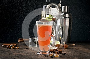 Hot buttered rum, autumn or winter warming alcoholic cocktail with apple and lemon juice, dark rum, honey, cinnamon in tall glass