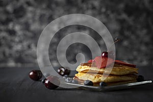Hot Cakes stacked with cherries, strawberries and blueberries photo