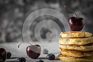Hot cakes with strawberries and cherries seen from close up