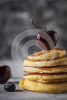 Hot cakes with strawberries and cherries seen from close up