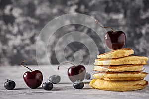 Hot cakes with strawberries and cherries seen from close up