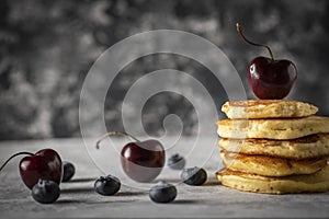 Hot cakes with strawberries and cherries seen from close up photo