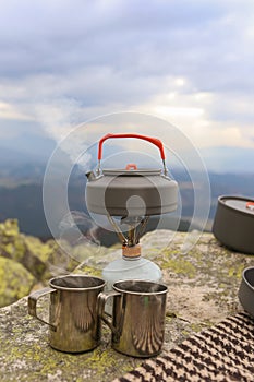 Hot camping teacup. Camping travel teapot and camping teacups in Carpathian mountains